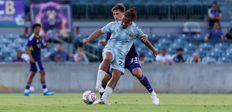 Player tackling opponent during Orlando City II match
