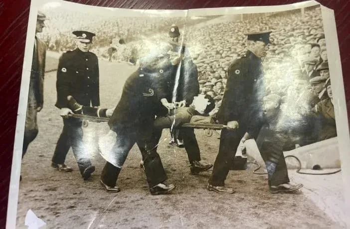 Stretcher bearers carrying an injured player off field