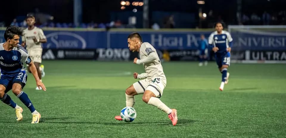 Player dribbling ball during Huntsville City match