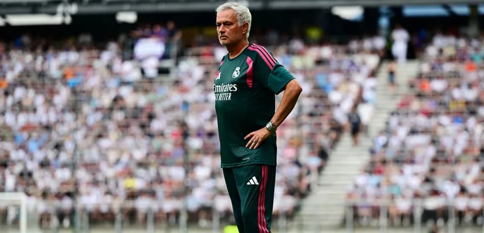 Manager observing the game with fans in background