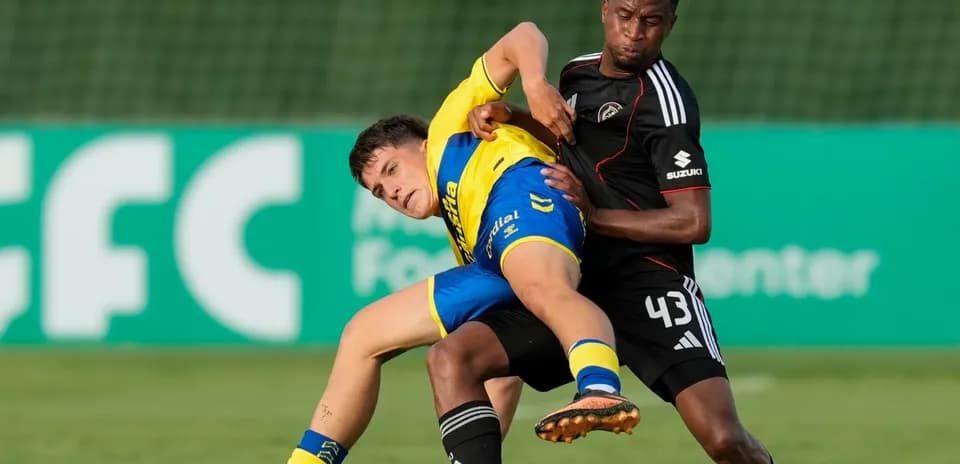 Two players battling for the ball on the field