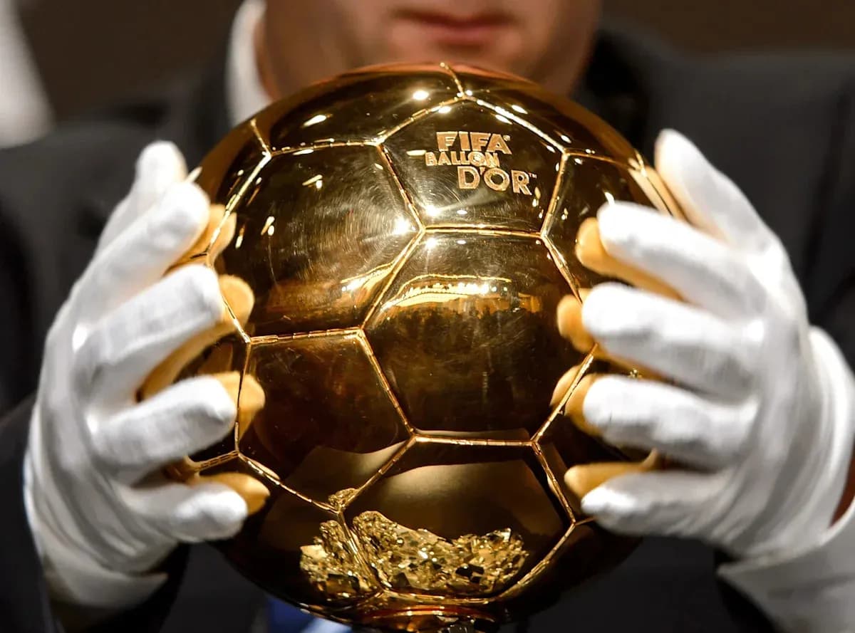 Person holding the FIFA Ballon d'Or trophy