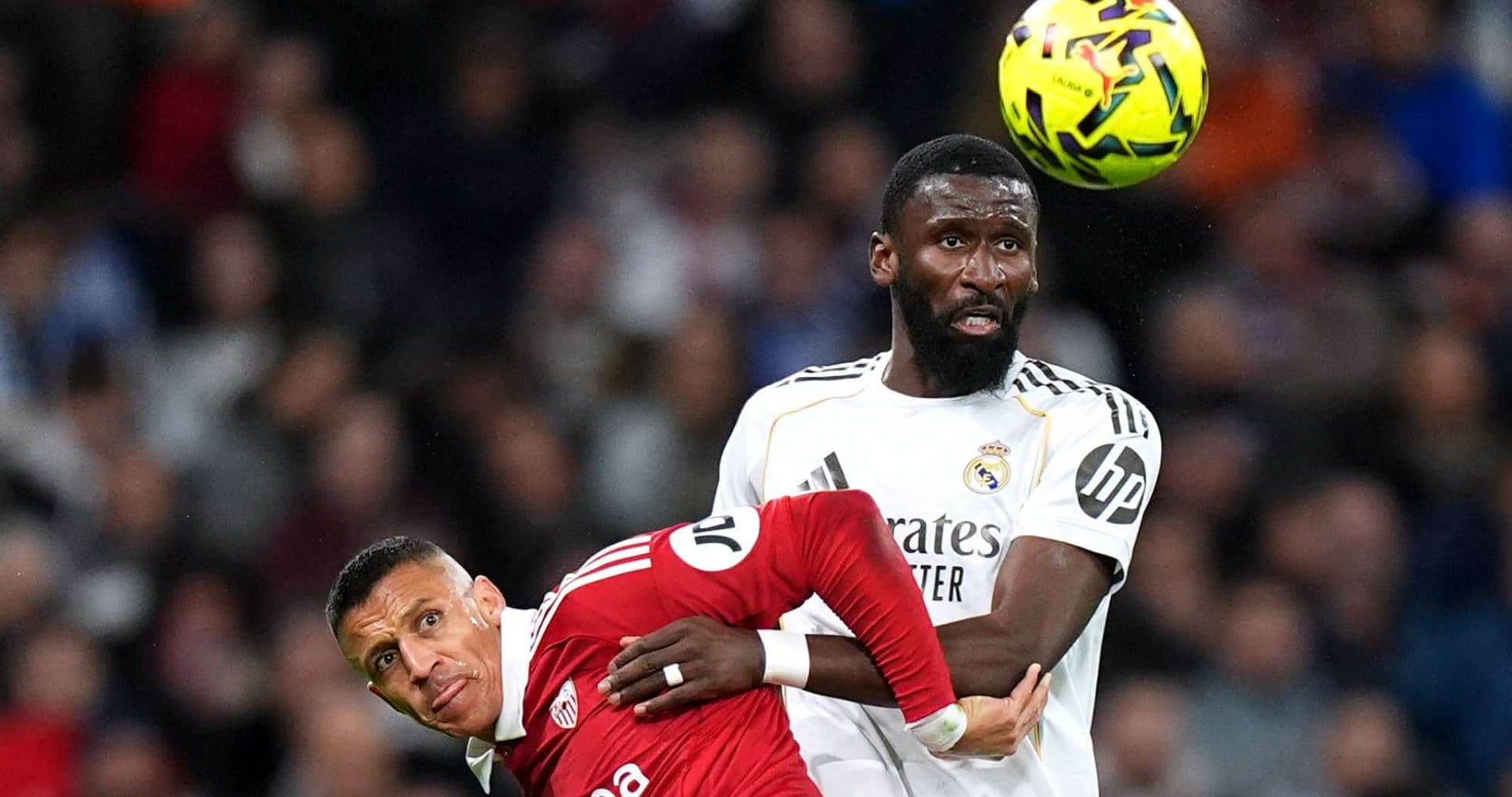Real Madrid player challenging Sevilla opponent