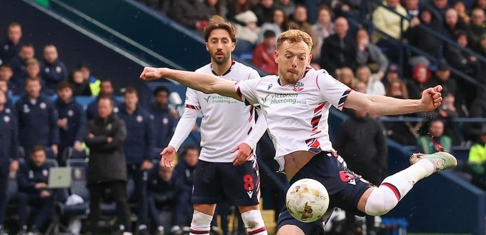 Player striking the ball during a football match