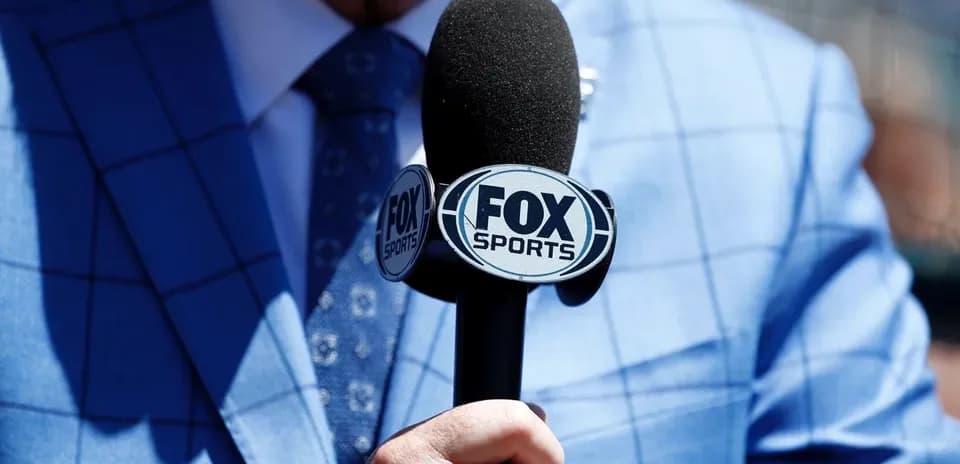 Reporter holding a FOX Sports microphone close-up