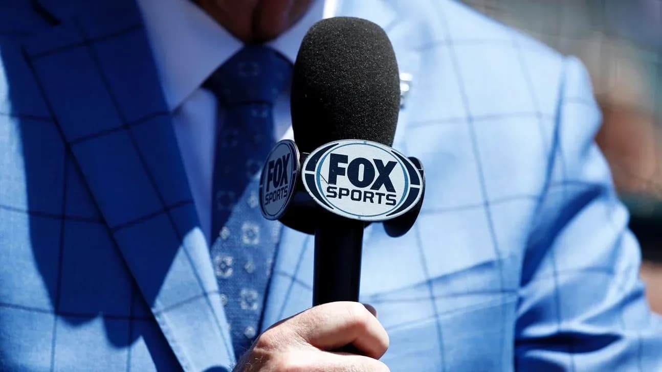 Reporter holding a FOX Sports microphone close-up