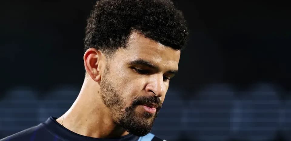 Player in training kit looking down thoughtfully