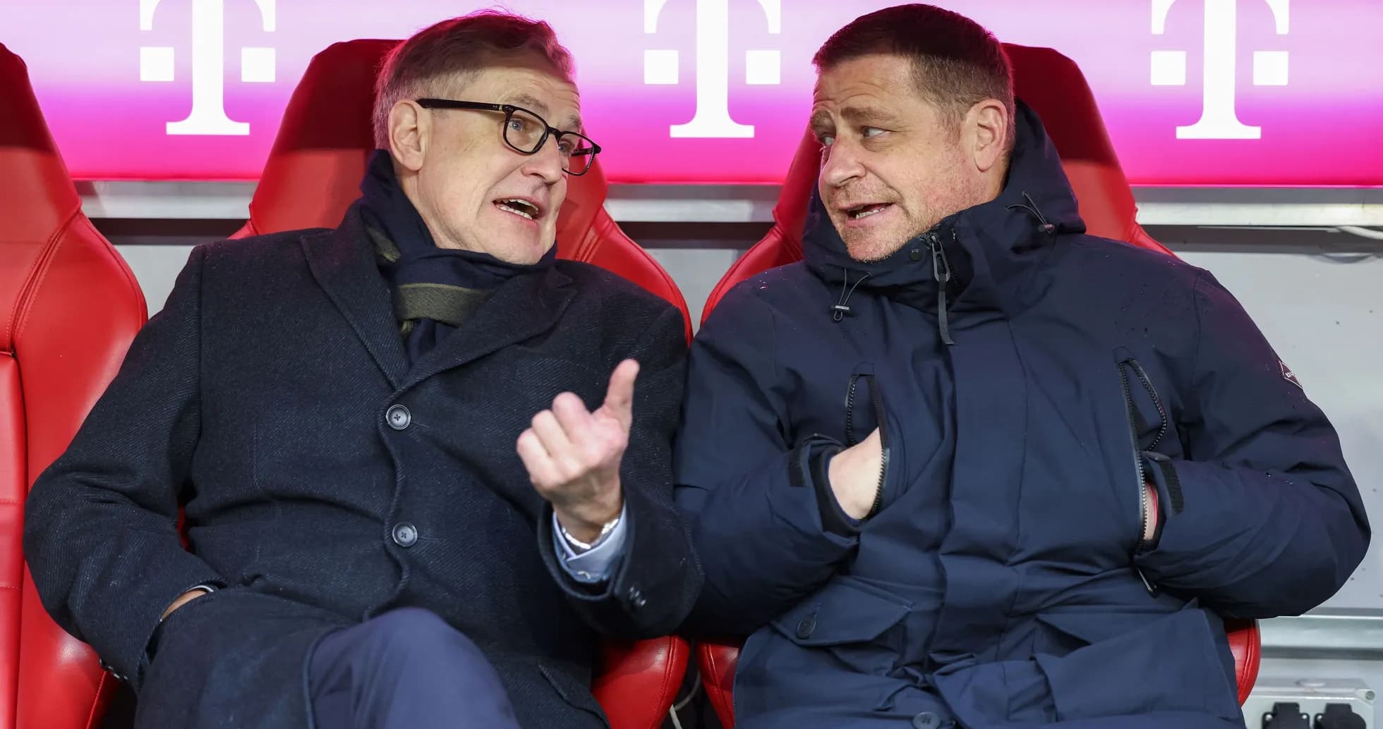 Two men conversing on the sidelines of a match