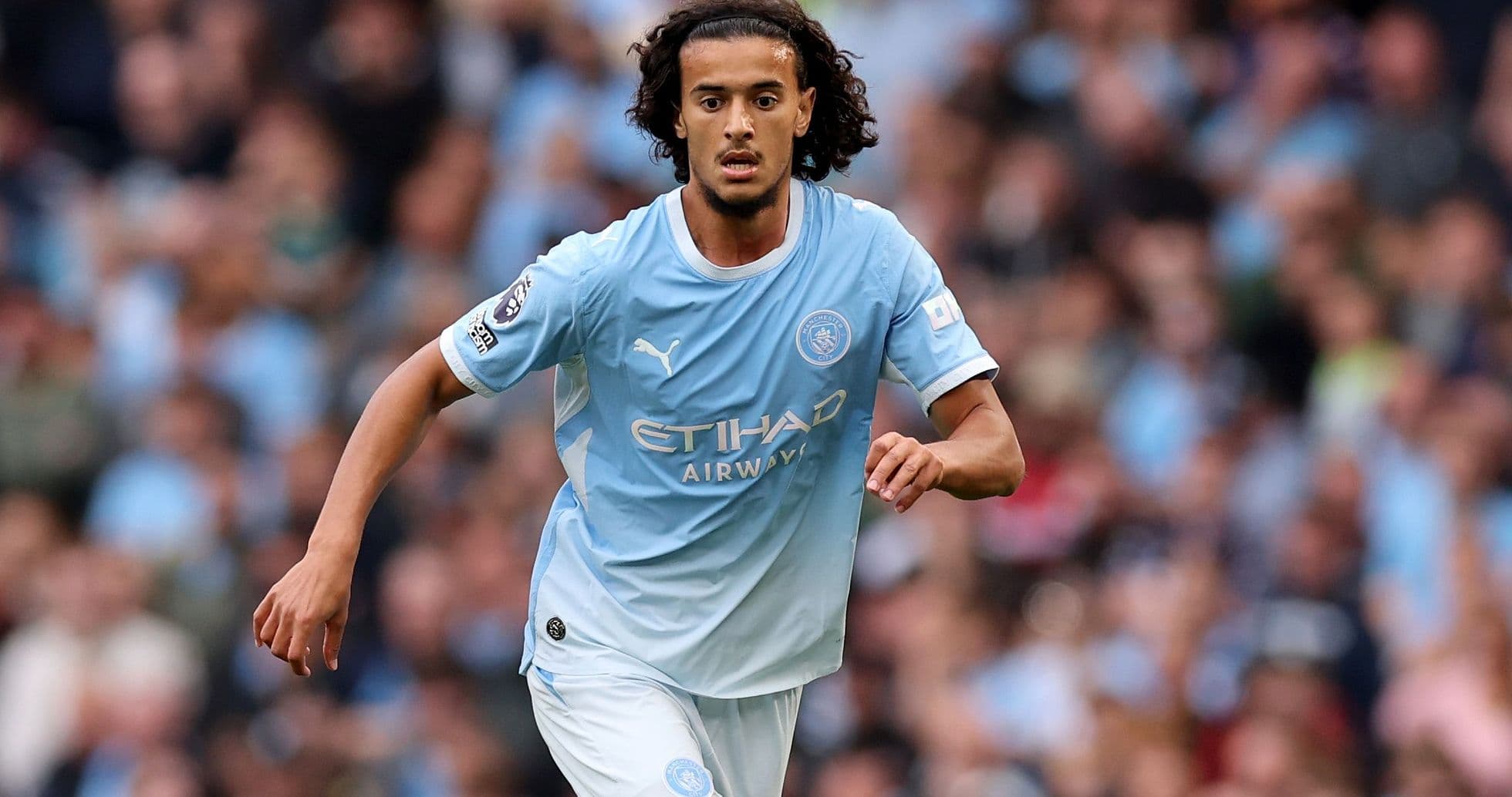 Player running with the ball in Manchester City kit