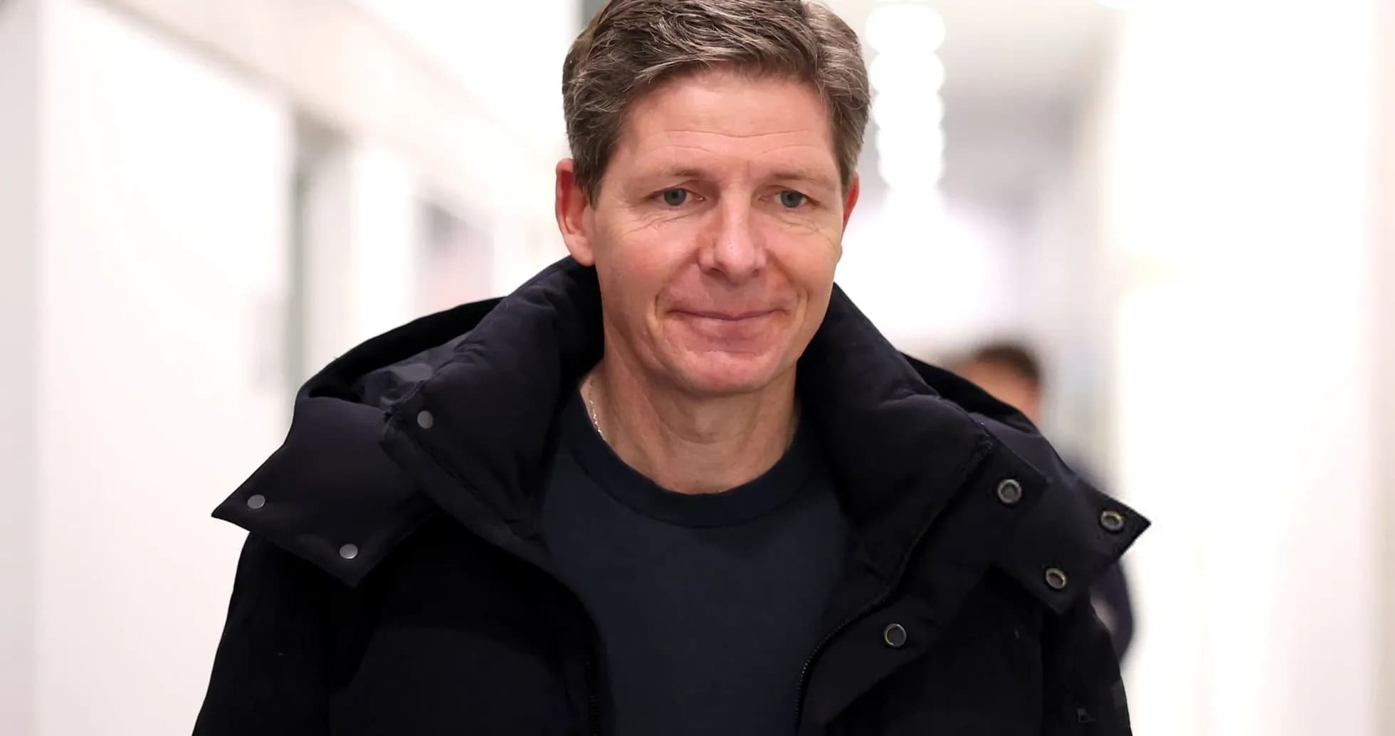 Person walking in a corridor wearing a jacket