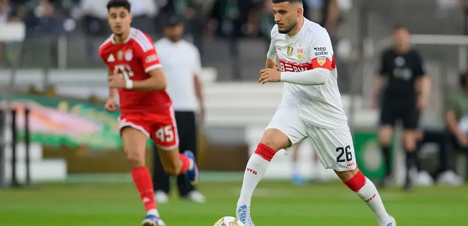 Player in white dribbling the ball during match