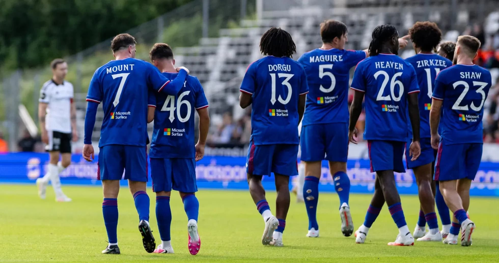 Players celebrating together on the field in blue jerseys