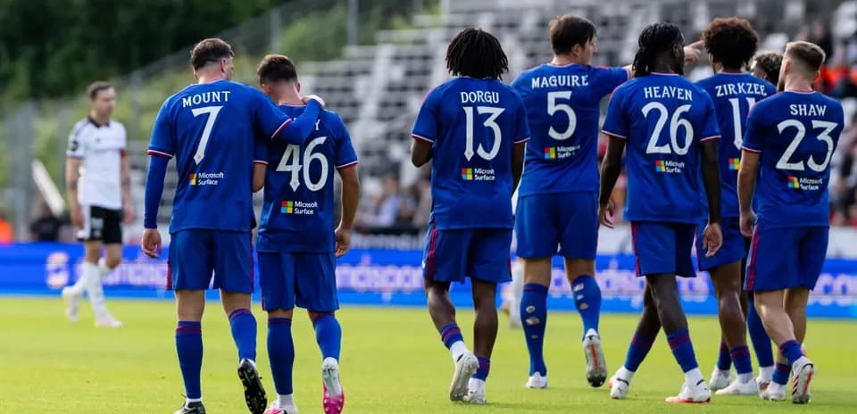 Players celebrating together on the field in blue jerseys