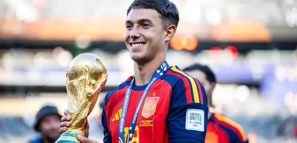 Player holding FIFA World Cup trophy on field