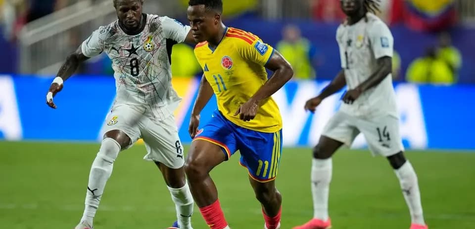 Colombian player dribbling past Ghanaian defender in match