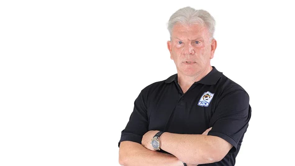 Coach with arms crossed in black polo shirt