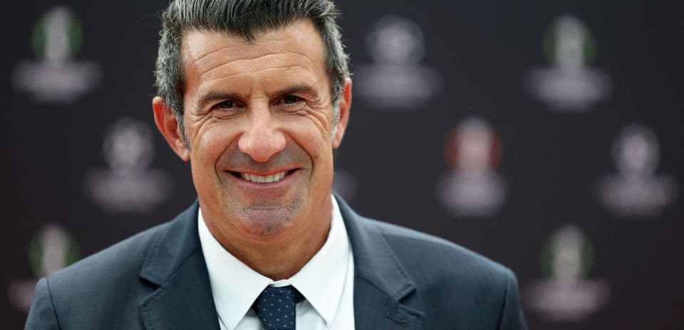 Man smiling in suit at event backdrop