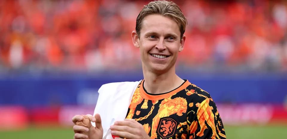 Player smiling in vibrant team-themed outfit on pitch
