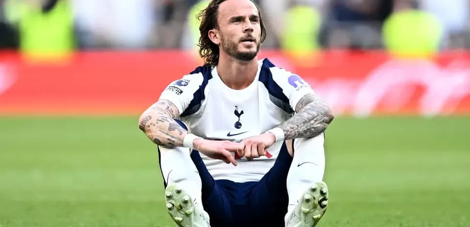 Player sitting on pitch after match wearing Tottenham kit