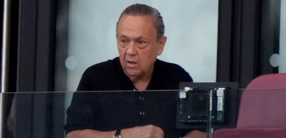 Man observing from a glass-enclosed VIP box