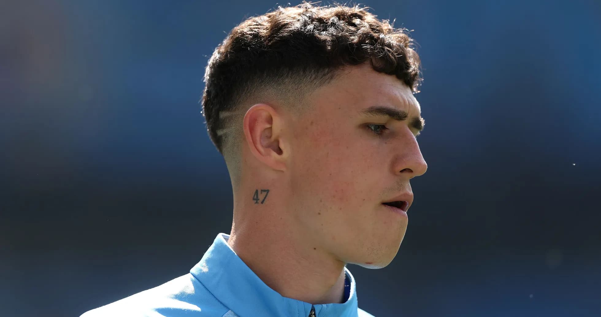 Player with short hair and neck tattoo during warm-up