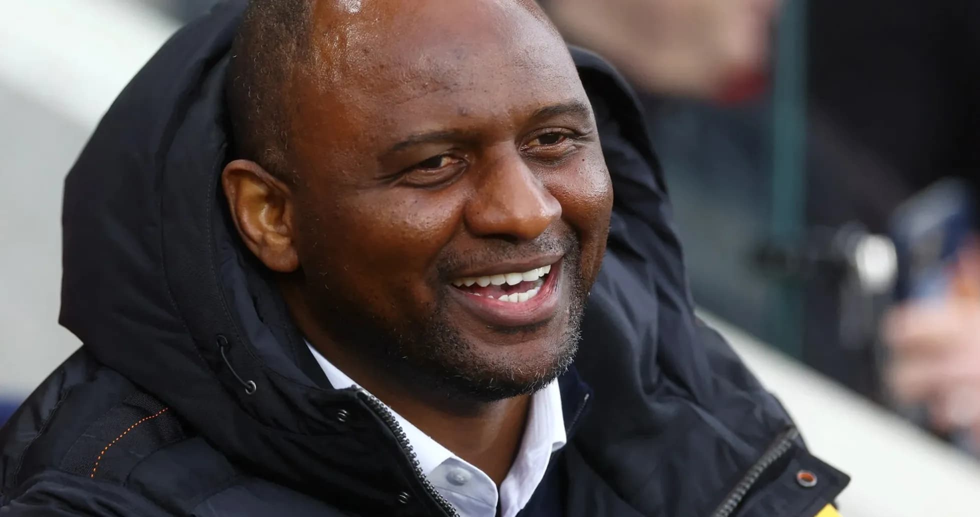 Man in black jacket smiling at the match