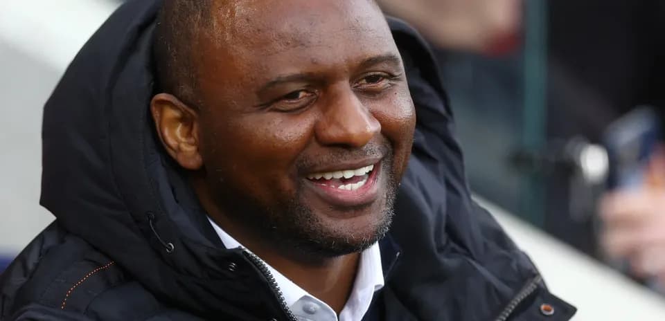 Man in black jacket smiling at the match
