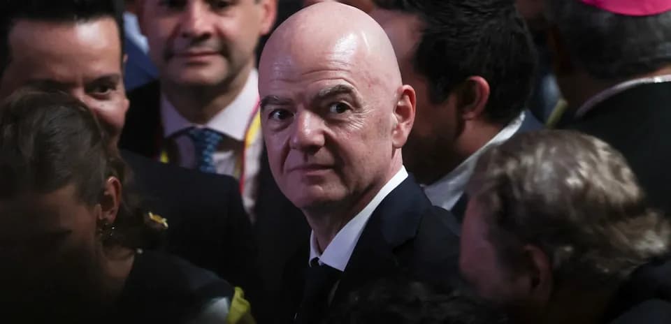 Man in suit surrounded by a crowd at event