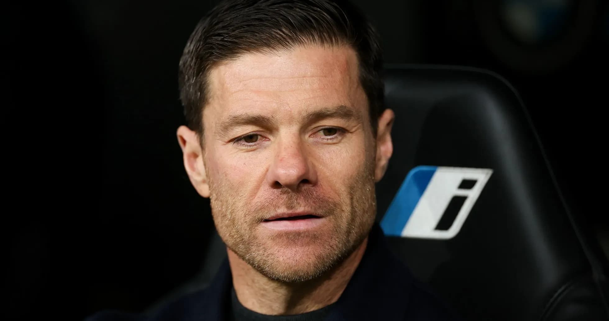 Coach seated on bench during a match