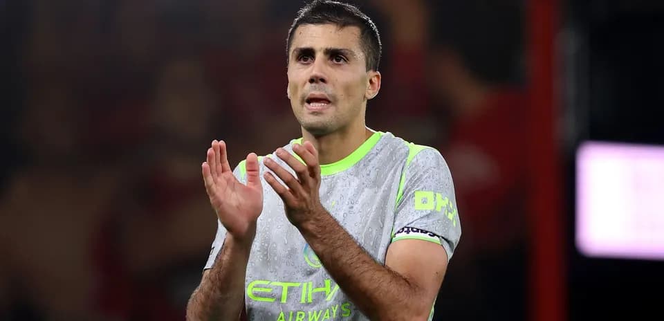 Player applauding in Manchester City kit on pitch