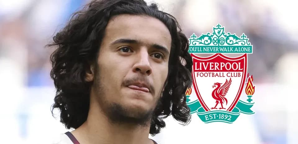 Player with curly hair next to Liverpool FC logo