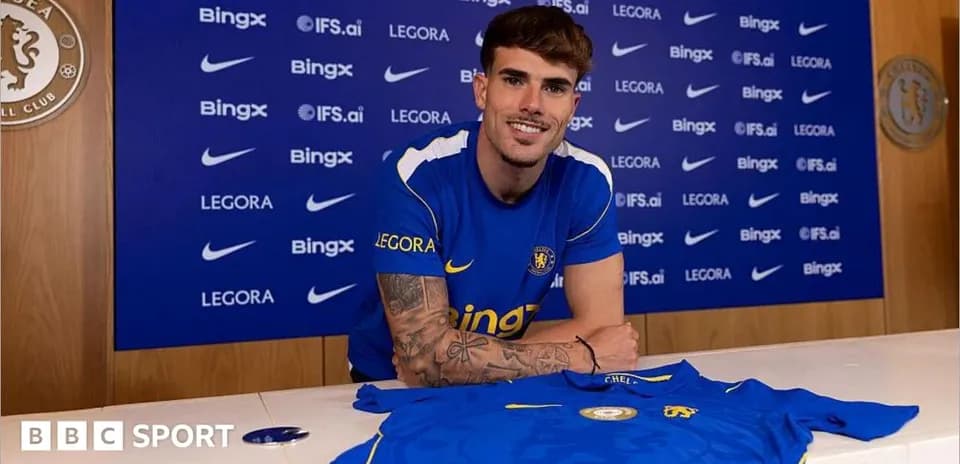Player posing with Chelsea shirt at signing event