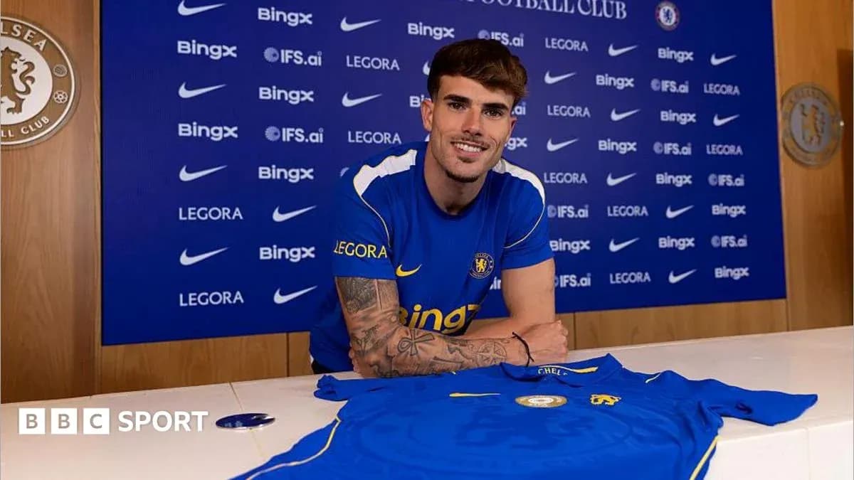 Player posing with Chelsea shirt at signing event