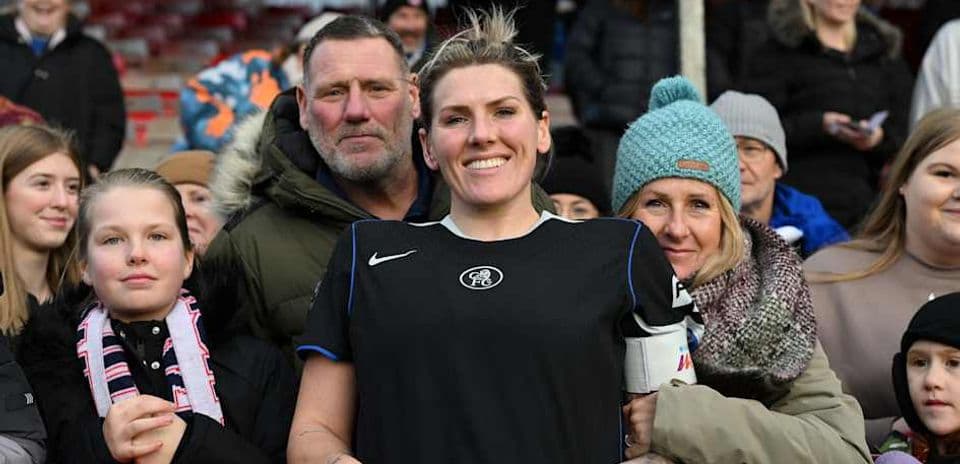 Player smiling with fans at stadium railing