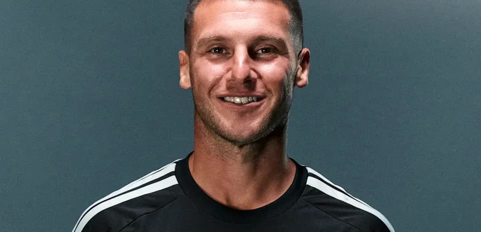 Player smiling in black training kit with stripes