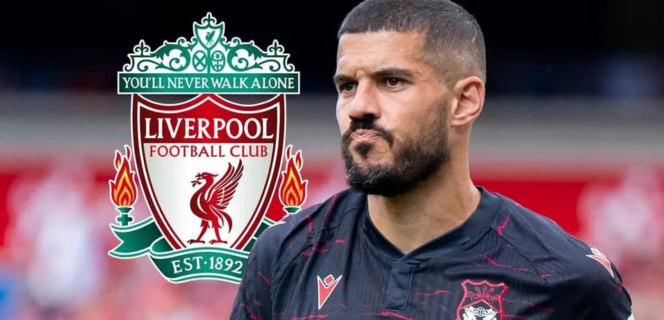 Player in black jersey with Liverpool logo backdrop