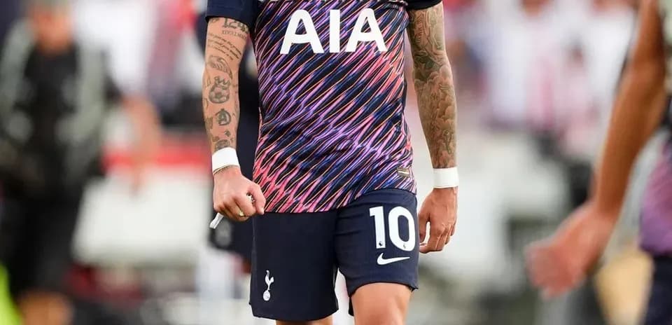 Player in Tottenham jersey walking on the pitch