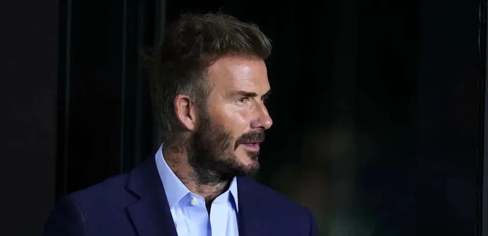 Man with tattoos wearing a suit, profile view