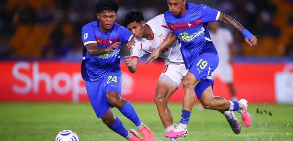 Two players tackling an opponent during football match