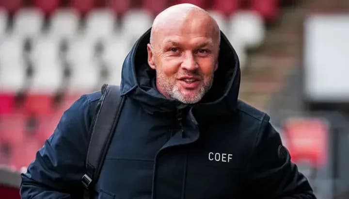 Man in a jacket smiling while walking