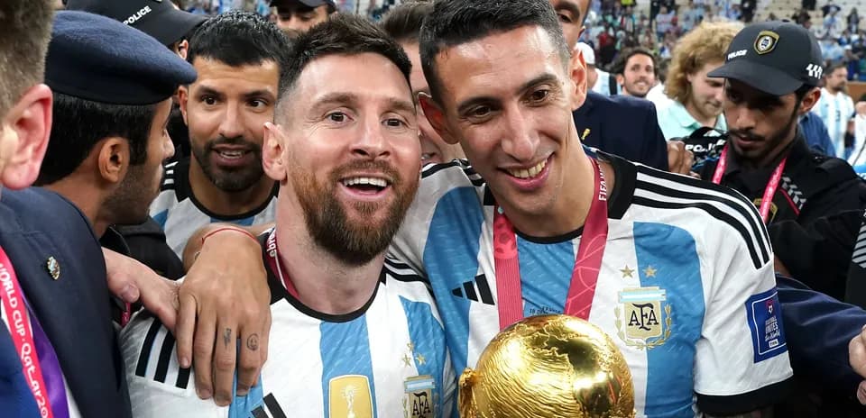 Lionel Messi and Angel Di Maria celebrating with trophy