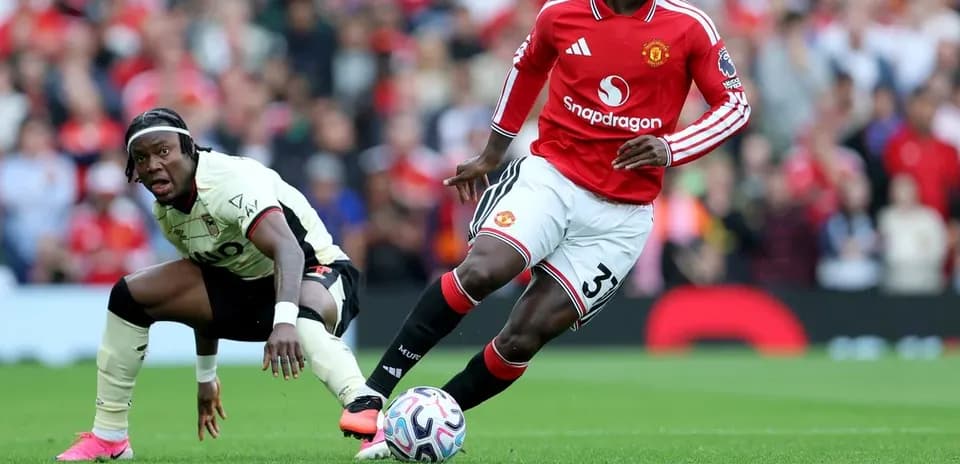 Manchester United player dribbling past opponent during match