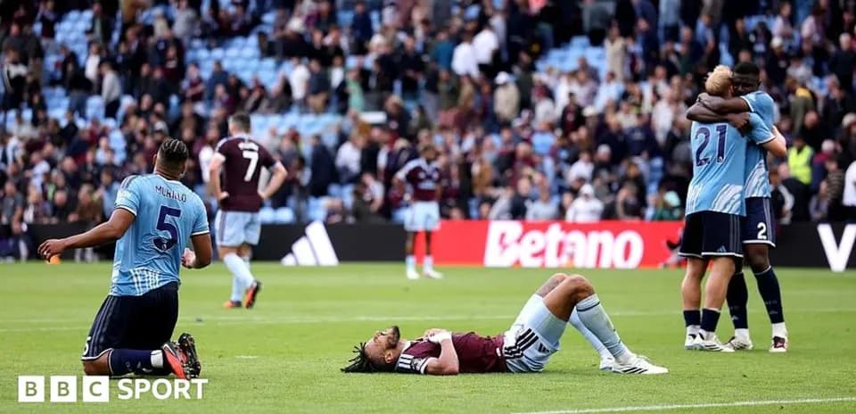 Players reacting after match with fans in background