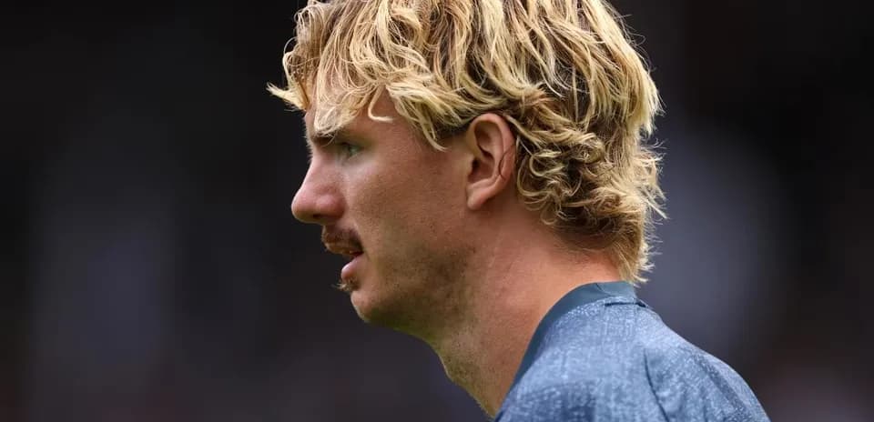 Player with blonde curly hair in profile