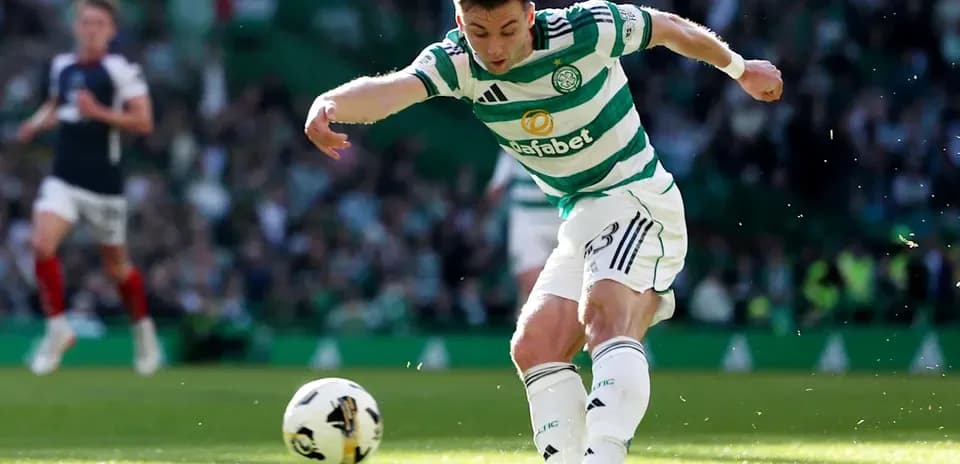 Celtic player kicking ball during match action