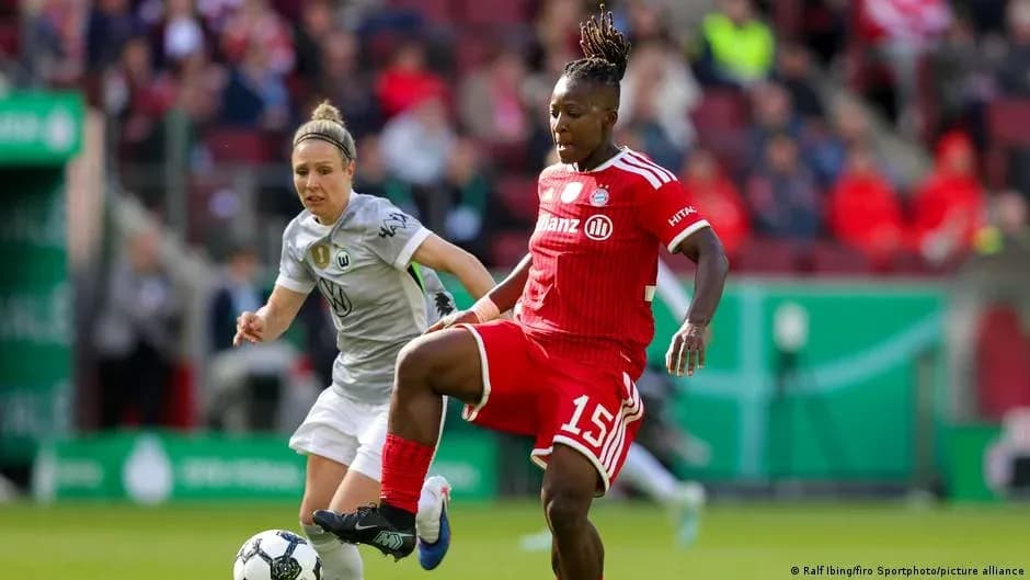 Two female football players competing for the ball