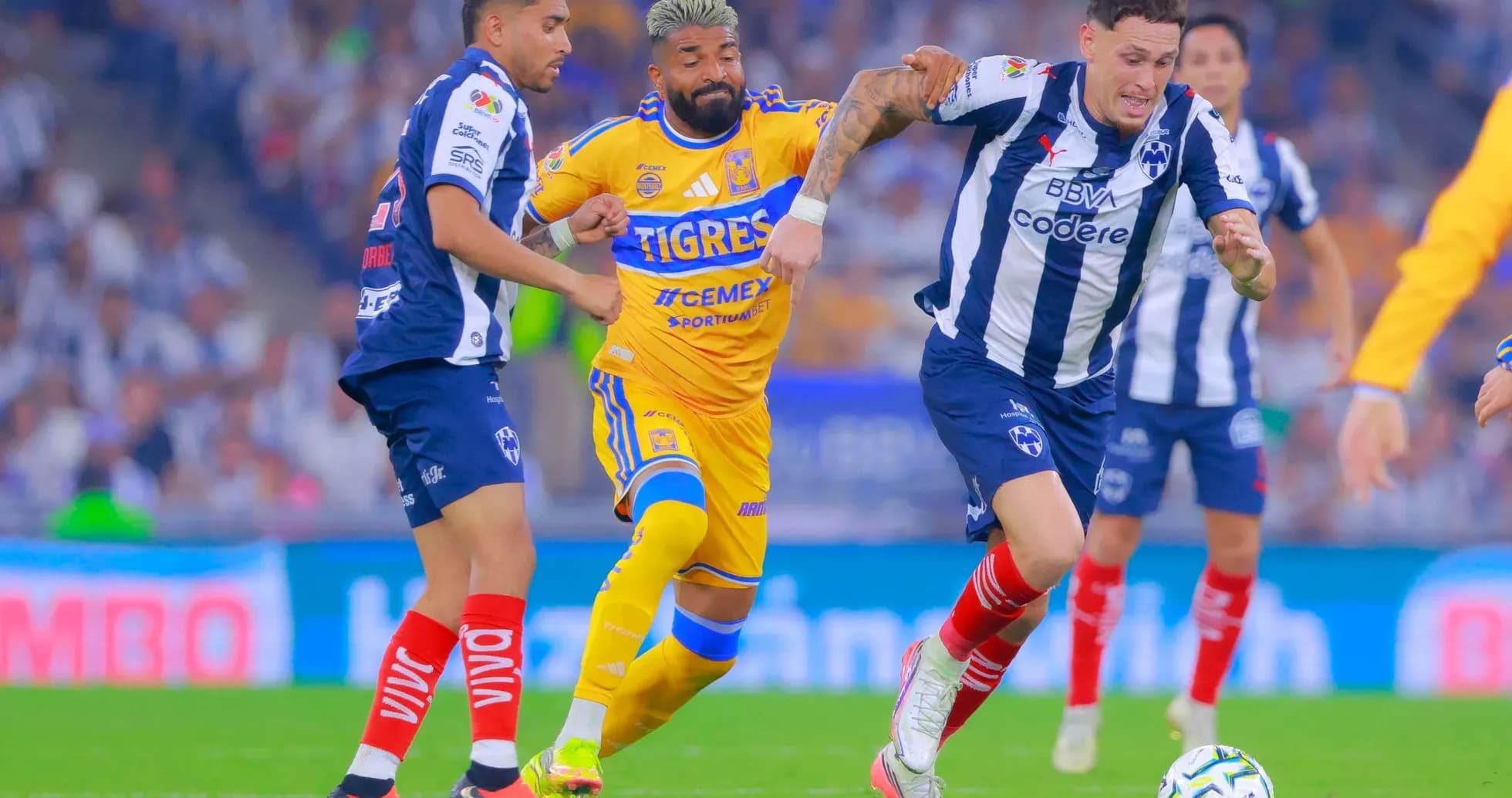 Monterrey players challenging Tigres UANL during match