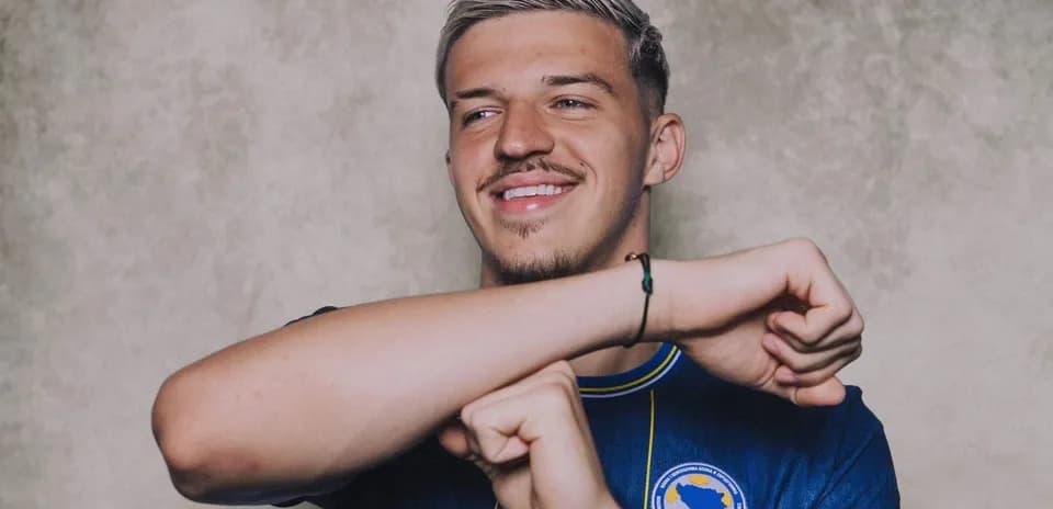 Player posing in national team jersey with smile