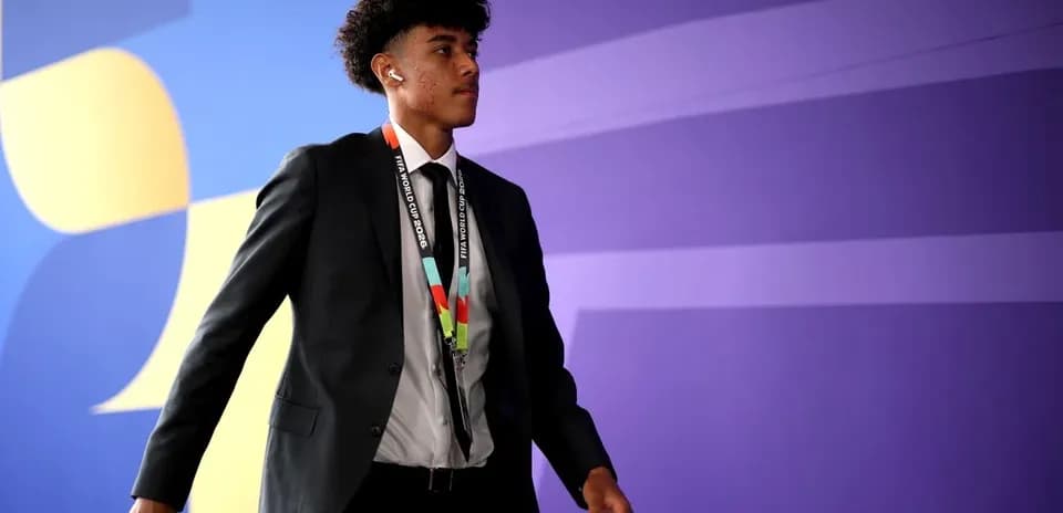 Player in suit walking with FIFA World Cup pass