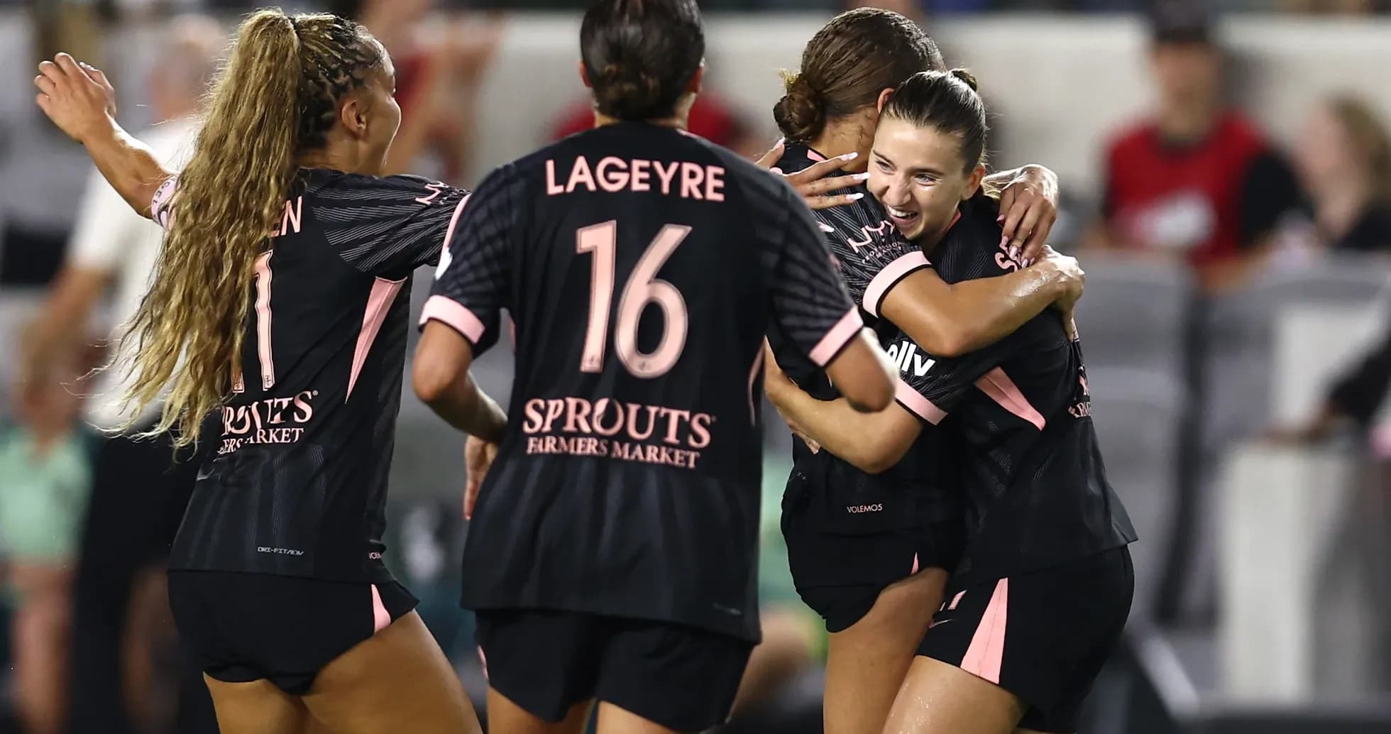 Players celebrating a goal during NWSL match